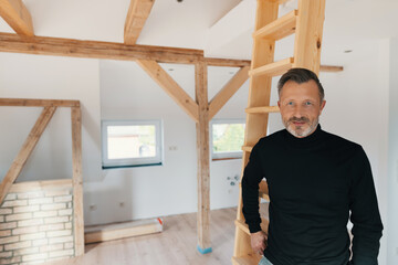 Man standing in his attic looking intently at the camera
