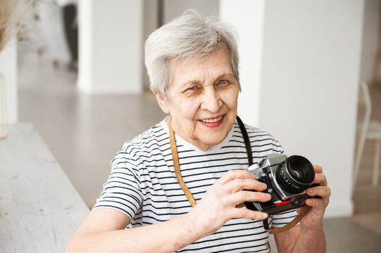 Portrait of a beautiful elderly woman with a camera.