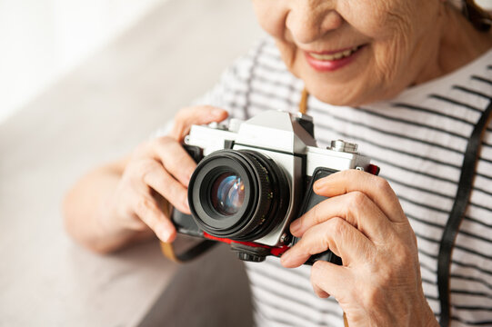 Retro camera in the hands of an elderly woman.