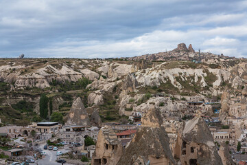 Fototapeta na wymiar トルコ　カッパドキアのギョレメの街並みと街中にある洞窟住居と遠くに見えるウチヒサール城