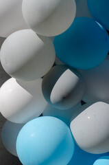 Colorful helium balloons. A group of blue, white, gray holiday balloons. Close-up. Selective focus.