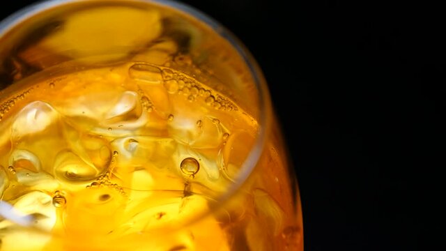 くるくる回転した氷とドリンクのクローズアップ動画。コーヒーやウィスキーなど。