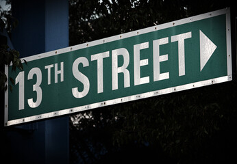 Illuminated street sign pointing right to 13th Street - obrazy, fototapety, plakaty