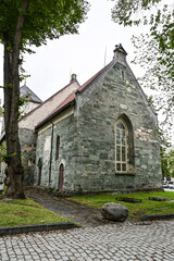 Old school bike leaning against small misty grey church in Trondheim 