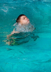 boy swimming in blue swimming pool