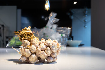 Garlic Bundle in studio light on the white marble surface table, prepare for a food demonstration behind.