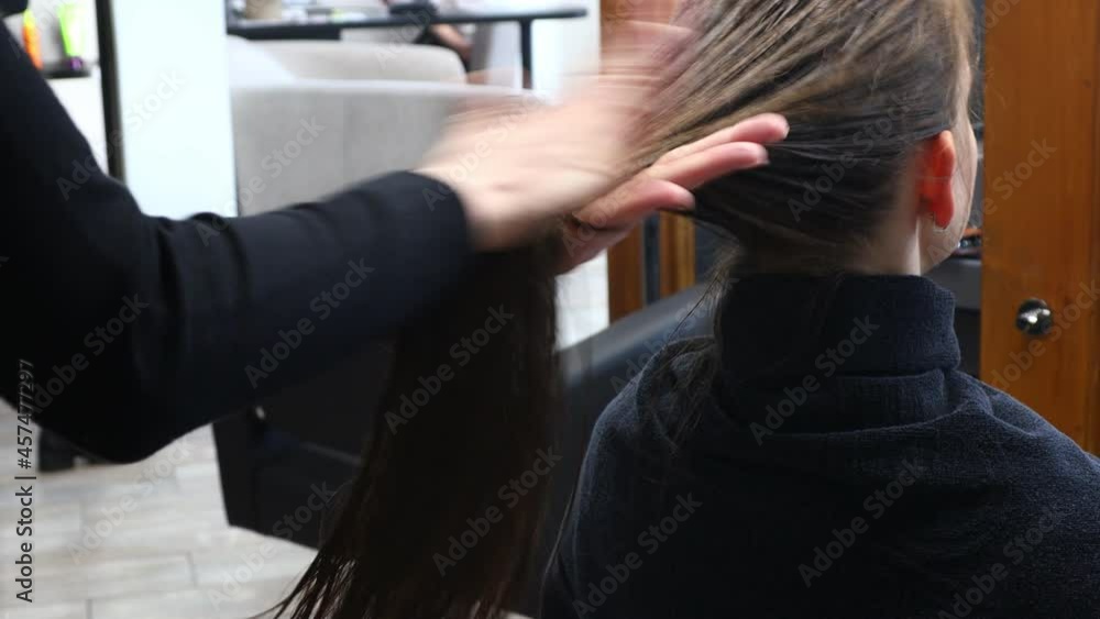 Canvas Prints Master woman hairdresser carefully applies a special conditioner for hair after washing the girls head in a beauty salon.