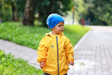 autumn in the park little boy walking in a raincoat seasonal look