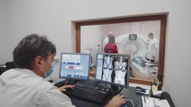 The doctor examines the patient's tomography on a computer. Magnetic resonance imaging