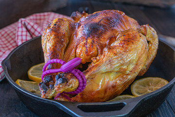 Roasted whole chicken on rustic and wooden table