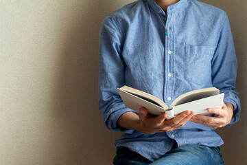 室内で座って読書する青いシャツを着た女性