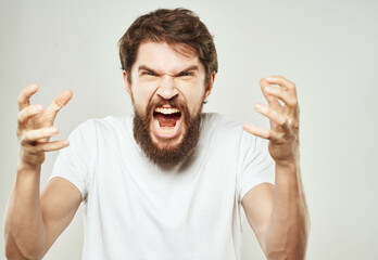 Man in a white t-shirt hand gestures anger close-up