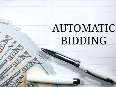 Finance Concept.Text AUTOMATIC BIDDING Writing On Notebook With Pen And Banknote.