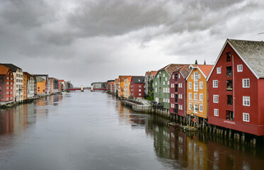 Fototapeta premium Typical colorful scandinavian buildings on a river in Trondheim in a cloudy rainy day