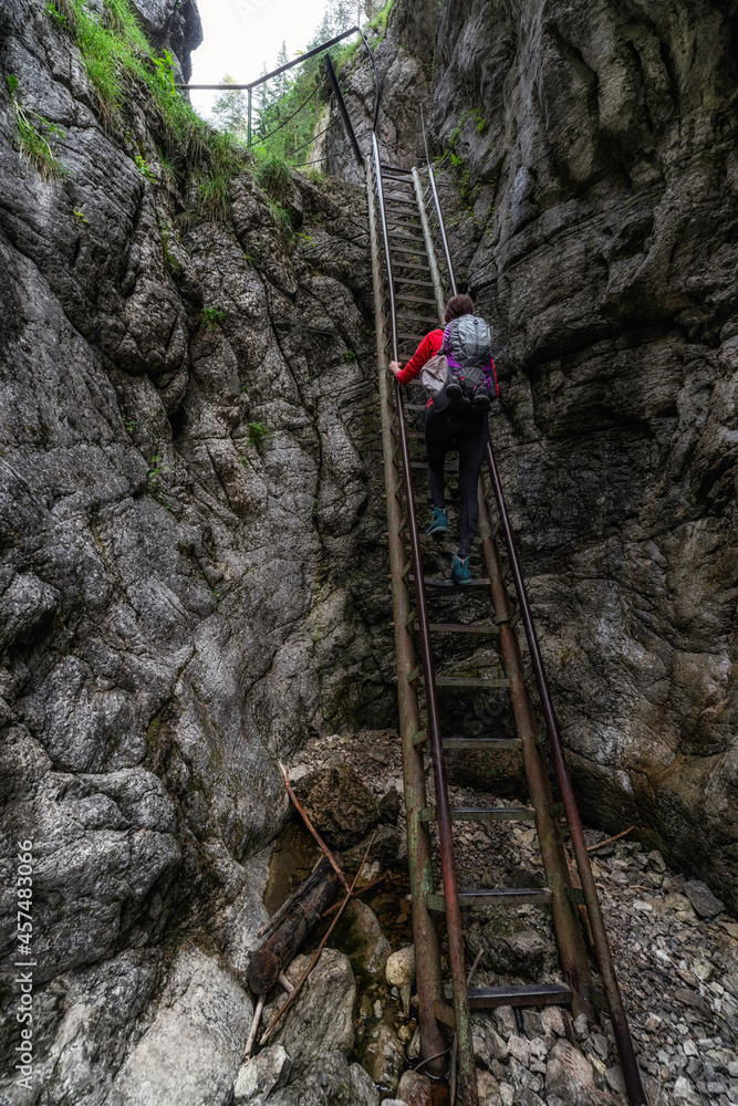 Canvas Prints Girl hiker on ladder on a rocky hiking trail in Prosiecka valley, Slovakia