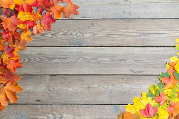 Fallen leaves on a wooden table. Yellow and red leaves on old table boards. Autumn leaves fallen on...