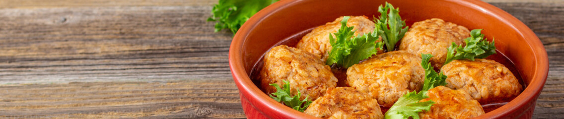 banner of Meatballs in tomato sauce in a bowl on wooden table.