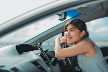 attractive asian women smiling and looking straight while driving a car. travel vacation Relaxing and enjoying concept.
