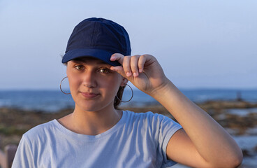 Teen girl in dark blue baseball cap and t-shirt