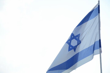 Israeli flag weaving in the wind against bright skies