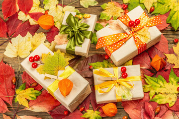 Naklejka na ściany i meble Zero waste gift concept with autumn design. Warm sweaters, fall leaves, thematic decor