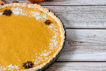 Delicious homemade American pumpkin pie. on a gray and woody background.