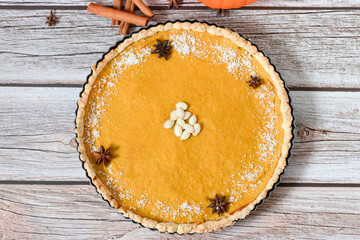 Delicious homemade American pumpkin pie. on a gray and woody background.