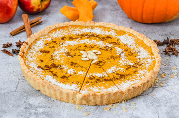 Delicious homemade American pumpkin pie. on a gray and woody background.