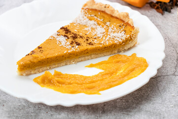 Delicious homemade American pumpkin pie. on a gray and woody background.