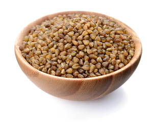 uncooked bitter buckwheat in the wooden bowl, isolated on the white background