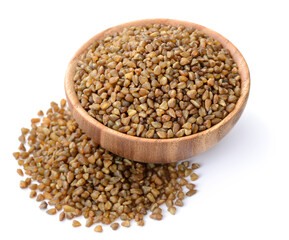 uncooked bitter buckwheat in the wooden bowl, isolated on the white background