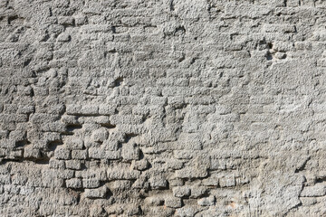 A wall made of brick, painted grey.