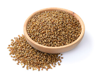 uncooked buckwheat in the wooden plate, isolated on the white background
