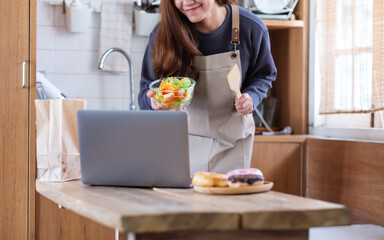 A female video blogger cooking food in the kitchen and filming for online learning cooking class concept