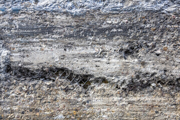 Textured surface of gray concrete wall with scratches and cracks