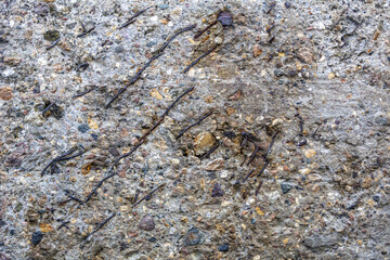 Textured surface of gray concrete wall with scratches and cracks