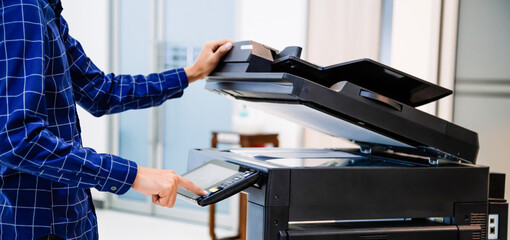 Businessmen press button on the panel for using photocopier or printer for printout and scanning...