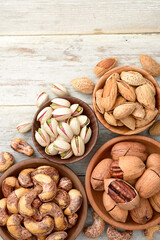 multiple roasted nuts on the wooden board, top view