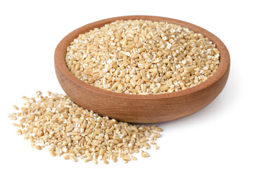 raw steel cut oats in the wooden plate, isolated on the white background
