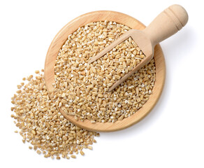 raw steel cut oats in the wooden scoop and plate, isolated on the white background, top view