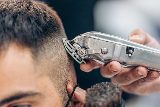 Close up view of a machine shaving the hair of a customer in a barbershop