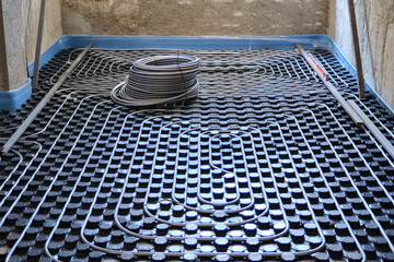 Radiant floor construction installation with flexible pipes.