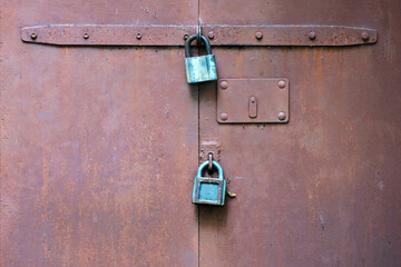 Old rusting metal gate with two padlocks. Space for lettering or design