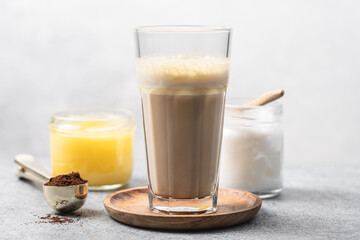 Glass Cup of bulletproof coffee and ingredients on white background. Ketogenic keto diet coffe blended with coconut oil and butter