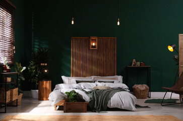 Stylish interior with large comfortable bed and potted plants
