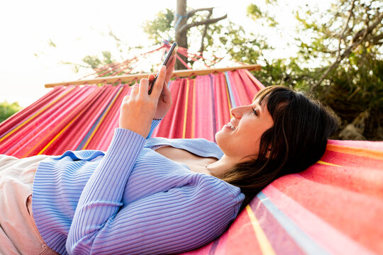 woman using mobile in hammock
