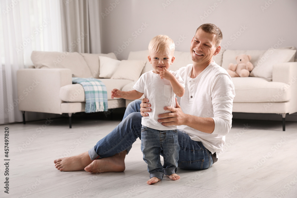 Wall mural father with his cute little son in living room