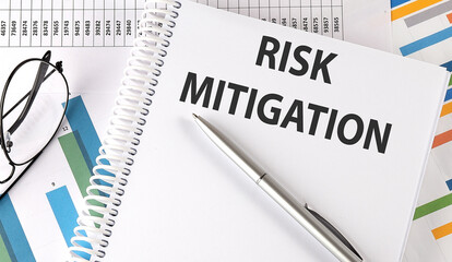 RISK MITIGATION text , pen and glasses on the chart,business concept