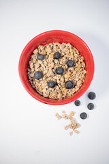 red bowl with cereals and blueberries