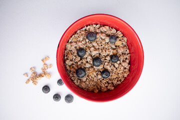 red bowl with cereals and blueberries